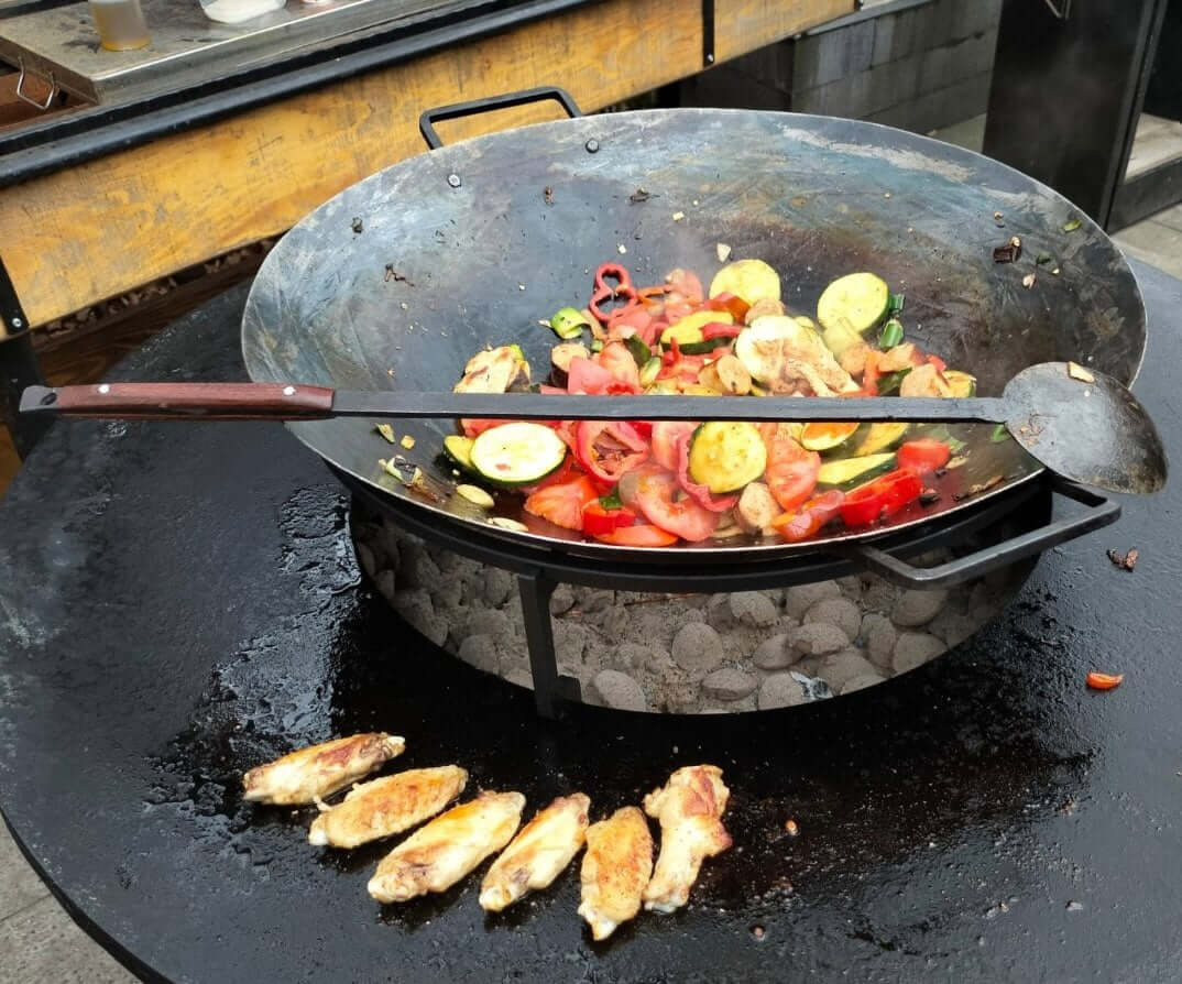 Fyreza Wok 55 Pro mit Gemüse auf einer Feuerplatte
